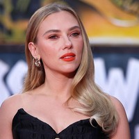 Untuk tampilan makeup, Johansson memilih lipstik matte oranye terang yang bold, dipadukan dengan eyeshadow rose gold dan bulu mata hitam pekat, kombinasi yang menonjolkan fitur wajahnya tanpa mengalahkan dominasi gaun. (Foto: Gerald Matzka/Getty Images)