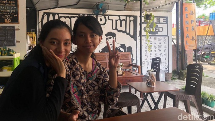 Goldia (kiri) sedang berbicara menggunakan bahasa isyarat dengan teman tulinya.