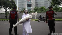 Seorang peserta aksi memeragakan teatrikal penderitaan warga Gaza sebagai bentuk solidaritas atas krisis kemanusiaan yang terus berlangsung.