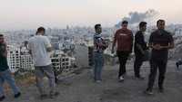 Warga bereaksi saat asap membumbung usai serangan Israel ke gedung IRIB, penyiar nasional Iran, di Teheran, Iran, Senin (16/6/2025). Menurut laporan Al Jazeera, bunyi ledakan terdengar di berbagai kota di Iran. Serangan ini tidak hanya terfokus di Teheran, tetapi juga menyasar daerah lain yang memiliki kepentingan strategis. (REUTERS/Majid Asgaripour)  