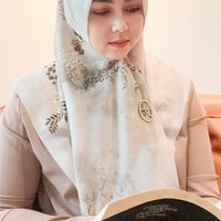 Melalui akun Instagramnya, Lala Nurlela kerap mengenakan hijab segi empat warna pastel. Salah satunya saat sedang membaca buku ini, ia mengenakan hijab segi empat cream yang dibentuk menutupi bagian dada. Ia menambahkan bros dengan logo merek hijab Syahrini, SYR, di bagian dada. Foto: Dok. Instagram @lala_nurlelaa.