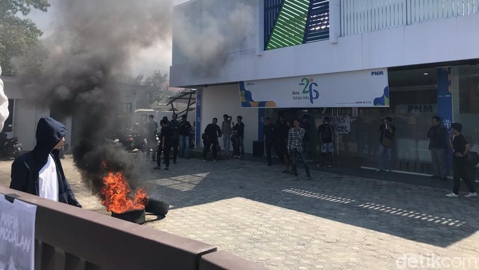 Massa mahasiswa melakukan unjuk rasa dan menyegel kantor PNM Palopo.
