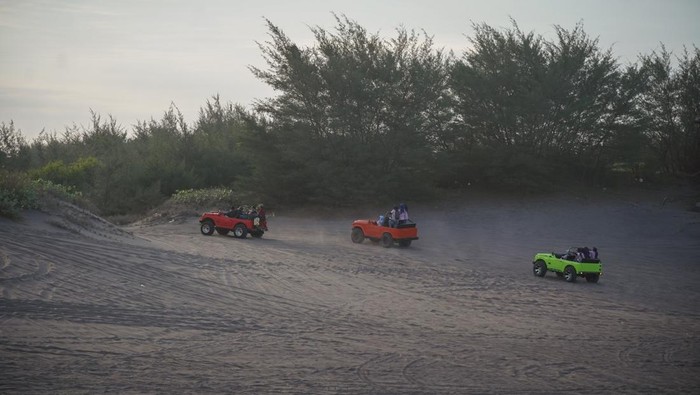 Pengunjung menaiki mobil jip wisata di kawasan Gumuk Pasir, Bantul, DI Yogyakarta, Kamis (19/6/2025). Kawasan Gumuk Pasir Parangtritis ditetapkan menjadi geopark atau taman bumi nasional karena memiliki keunikan berupa gundukan pasir berbentuk bulan sabit terbalik atau disebut barchan dari proses yang dipengaruhi oleh angin, material Gunung Merapi, Graben Bantul, Sungai Opak dan Sungai Progo yang membawa material dari Gunung Merapi. ANTARA FOTO/Hendra Nurdiyansyah/nym.
