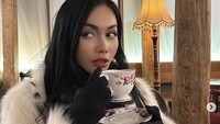 Dengan jubah berbulunya, sosok yang dikenal sebagai ‘Ratu rap Indonesia’ itu pergi ke kafe sambil menikmati segelas minuman hangat di cangkir berbunga. Foto: Instagram @denadaindonesia