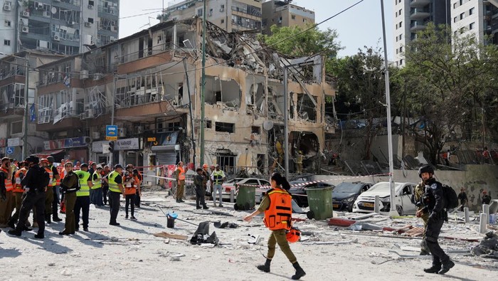 Serangan rudal Iran menghantam wilayah Ramat Gan, Israel, Kamis (19/6). Tim penyelamat bekerja cepat menangani kerusakan dan korban terdampak.