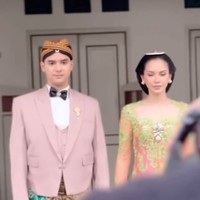 Di look kedua Alyssa dan Al tampil dengan busana adat Jawa modern yang lebih berwarna. Al tampak mengenakan jas yang dilengkapi dengan vest berwarna nude. Ia kemudian memadukannya dengan kemeja putih dan dasi kupu-kupu hitam. Sebagai bawahan, Al mengenakan kain lilit batik berwarna coklat. Foto: Instagram/@thebridedept