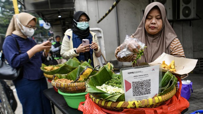 QRIS Tap Meledak! Jutaan Warga Beralih ke Pembayaran Digital Pedagang menyediakan alat pembayaran layanan Kode Respons Cepat Standar (QRIS) di Jakarta, Kamis (19/6/2025). Bank Indonesia (BI) mencatat jumlah pengguna (user) layanan QRIS Tap telah mencapai 47,8 juta orang sejak diluncurkan pada pertengahan Maret 2025 hingga Juni 2025. ANTARA FOTO/Muhammad Adimaja