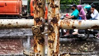 Pagar setinggi satu meter tertutup rapat, dililit kawat berkarat, menunjukkan tempat ini sudah lama tidak menerima pengunjung.  