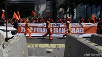 Sejumlah buruh membentangkan spanduk saat berunjuk rasa di depan kantor perwakilan PBB di Jl Thamrin, Jakarta, Jumat (20/6/2025).