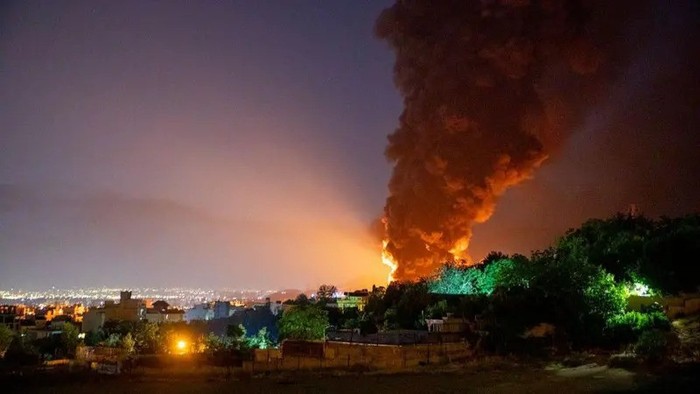 Asap dan api membubung ke langit setelah serangan Israel menghantam depot minyak Shahran di Teheran, Iran, pada 15 Juni 2025. (STRINGER/GETTY IMAGES)