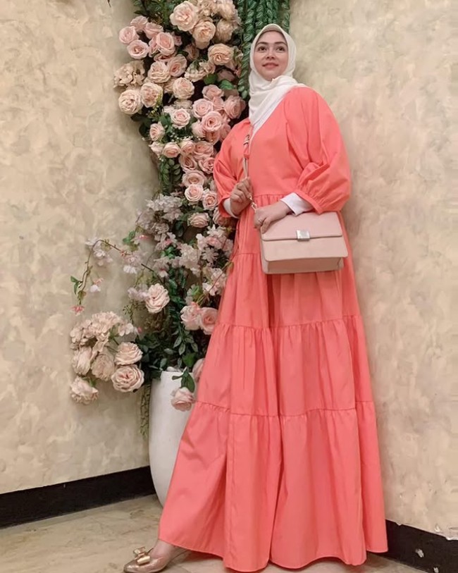 Tampil segar, Lala mengenakan dress warna coral dipadu dengan hijab segi empat putih dan sling bag warna baby pink, dilengkapi dengan flatshoes warna senada. Foto: Dok. Instagram @lala_nurlelaa.