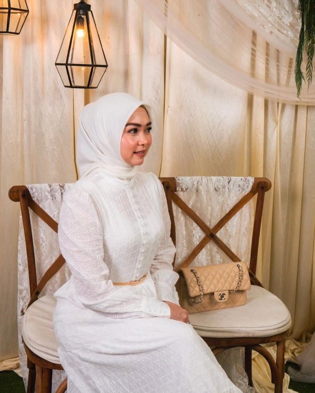 Lala Nurlela menunjukkan bahwa tampil anggun tak harus mengenakan aksesori berlebih. Seperti gayanya kali ini, ia memakan hijab segi empat yang dililit rapi ke belakang dan dress warna putih. Foto: Dok. Instagram @lala_nurlelaa.