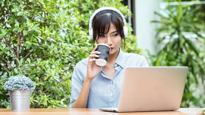 Asian young woman relaxing by listening music with laptop feeling so happiness