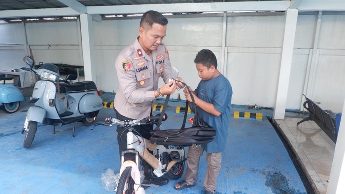 Kapolsek Pademangan Kompol Immanel Sinaga memberikan sepeda dan tas kepada salah satu anak bernama Alfin. (Dok Istimewa)