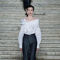 Garis desain koleksi ini terlihat dari siluet yang meminjam gaya dandy Napoli dan bintang film layar perak: celana pendek dengan lipatan, kerah potret yang dramatis, hingga gaun bertabur kristal yang menyapu anak tangga marmer dengan anggun. (Foto: Giovanni Giannoni/WWD via Getty Images)
