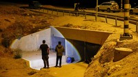 Warga berdiri di luar terowongan di bawah jembatan yang mereka gunakan sebagai tempat berlindung jika ada peringatan sirene roket Iran. Foto: REUTERS/Amir Cohen