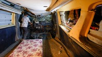 Seorang anak laki-laki bermain di dalam minibus yang terkubur yang digunakan sebagai tempat perlindungan bom. Foto: REUTERS/Amir Cohen