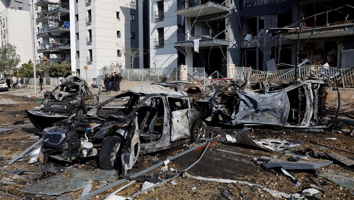 Mobil-mobil Hancur Usai Serangan Rudal Iran Menghantam Israel A view of burnt cars and a damaged residential building at an impact site following Iran's missile strike on Israel, in Be'er Sheva, Israel, June 20, 2025. REUTERS/Amir Cohen TPX IMAGES OF THE DAY