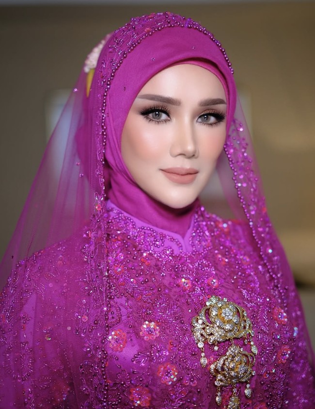 Dalam momen spesial ini, keluarga Ahmad Dhani kembali menunjukkan kekompakan mereka. Mulan Jameela tampil memukau dengan kedua putrinya, Tiara dan Safeea Ahmad. Ketiganya serasi mengenakan kebaya pink fuschia yang membuat penampilan mereka begitu anggun dan memikat. Mulan memadukan kebaya pink berhias payet dengan hijab dan kerudung senada, menghadirkan kesan lembut sekaligus berkelas. Wajahnya dirias manis dengan pulasan blush on pink dan tata rias mata yang lebih bold. Foto: dok. Instagram