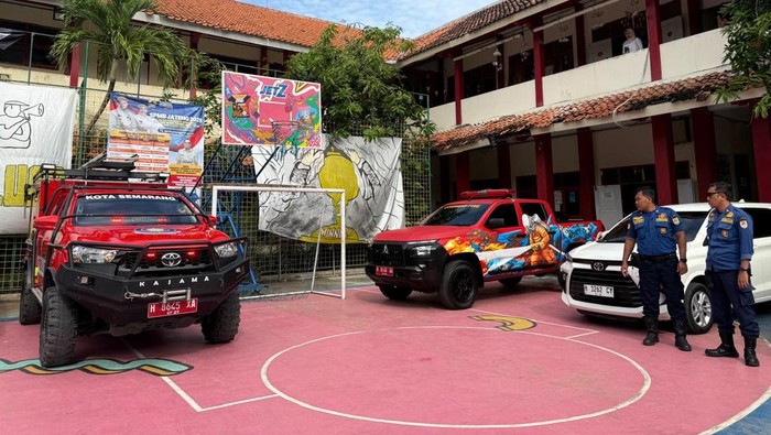 Petugas Damkar Kota Semarang membantu mengambilkan rapor seorang anak di SMAN 15 Semarang, Jumat (20/6/2025).