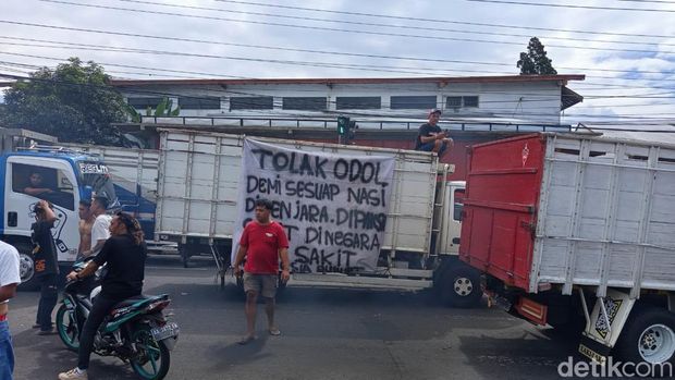 Sopir memasang spanduk protes di truknya saat demo di Parakan, Temanggung, Jumat (20/6/2025). Para sopir memprotes kebijakan zero ODOL.