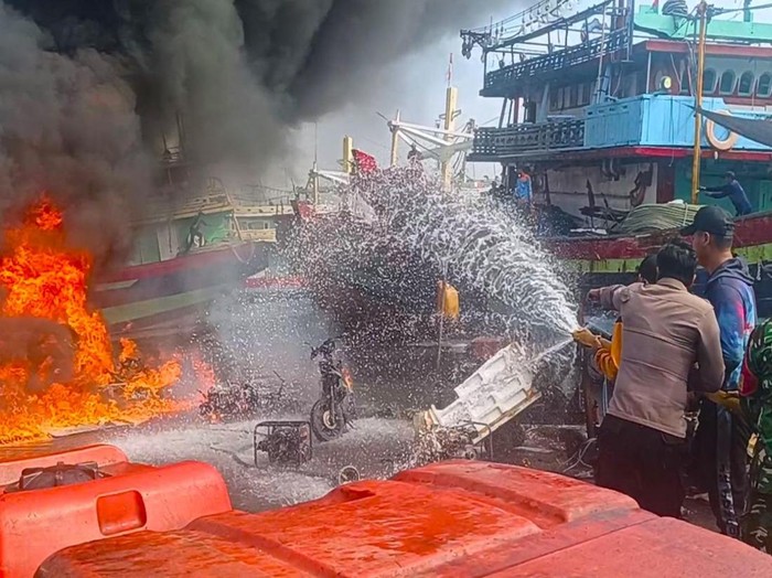 Anggota Polres Tegal Kota dan tim gabungan memadamkan kebakaran 1 kapal dan 16 sepeda motor di Dermaga Pelindo, Jumat (20/6/2025) siang.