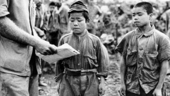 Marinir Amerika Utara mencoba berkomunikasi dengan dua anak tentara Jepang yang ditangkap di Okinawa, Juni 1945 Foto: Boredpanda