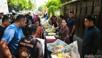 Perayaan ulang tahun itu digelar sederhana. Tumpeng dan kue dari warga serta relawan ditata berjejer. Tikar dan kursi disiapkan untuk warga.