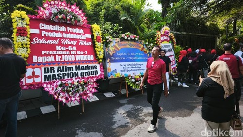 Karangan bunga ucapan selamat ulang tahun ke-64 hingga sosok pria mirip Jokowi asal Bandung, di depan rumah Jokowi di Kelurahan Sumber, Banjarsari, Solo, Sabtu (21/6/2025).