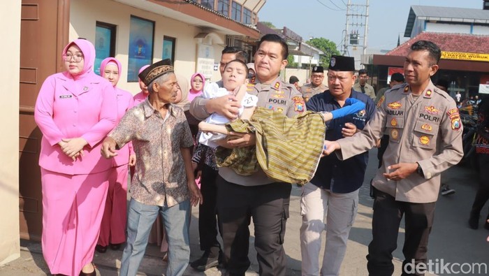 Kapolres Blitar AKBP Arif Fazlurrahman saat menggendong peserta khitan massal yang difabel.