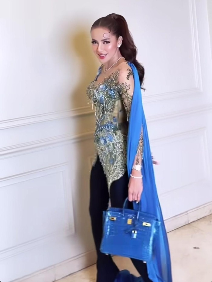 Olla Ramlan Olla Ramlan berkebaya biru, dipadu dengan celana panjang, dan tas Hermes.