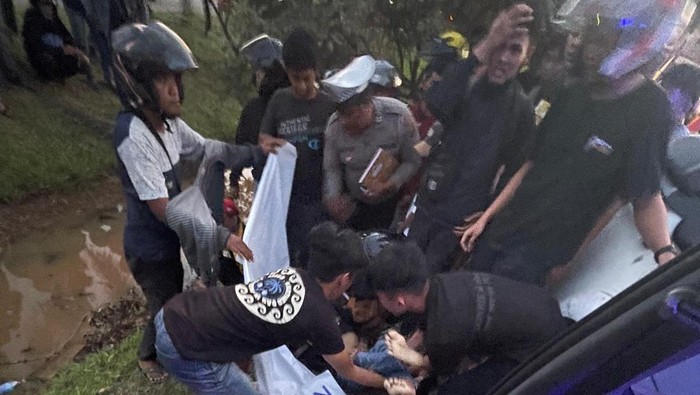 Polisi saat mengevakuasi korban kecelakaan di Palembang