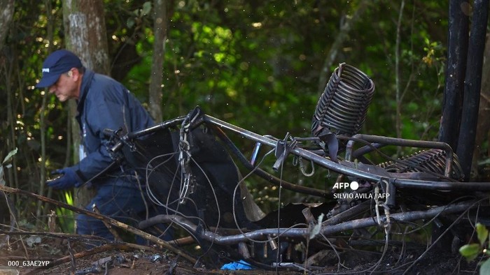 Seorang anggota Pusat Investigasi dan Pencegahan Kecelakaan Penerbangan (CENIPA) berjalan di samping reruntuhan balon udara yang terbakar dan jatuh dengan 21 orang di dalamnya di Praia Grande, Negara Bagian Santa Catarina, Brasil bagian selatan, pada tanggal 21 Juni 2025. Sedikitnya delapan orang tewas dan 13 lainnya luka-luka setelah balon jatuh puluhan meter ke tanah akibat kobaran api di Brasil bagian selatan, demikian dilaporkan gubernur Santa Catarina, Jorginho Mello.