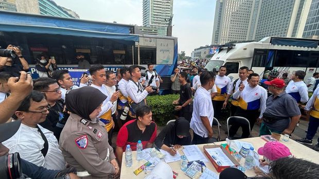 Ditlantas Polda Metro Jaya layani ratusan kendaraan yang perpanjang STNK di Samsat keliling di CFD Bundaran HI, Minggu (22/6/2025).