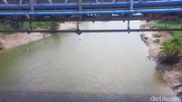 Kondisi air sungai setelah pencemaran limbah, warna biru pekat mulai memudar dan hampir hilang, namun masih terlihat kebiruan di bagian tengah sungai