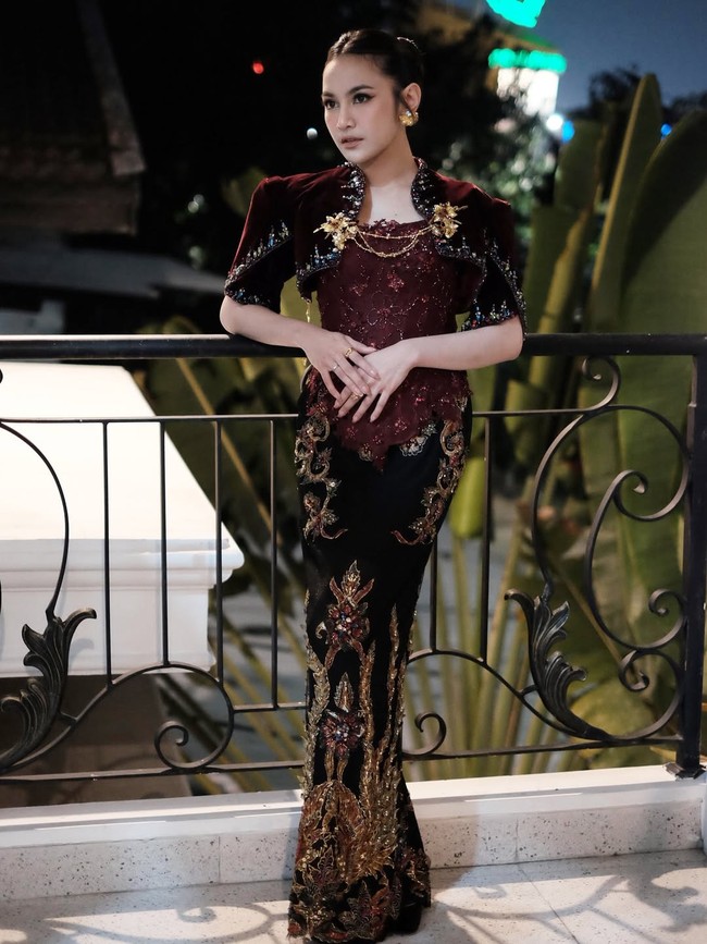 Bolero terbuat dari bahan beludru dengan hiasan rhinestones warna-warni dan bros emas. Ibu satu anak ini juga melengkapi penampilannya dengan perhiasan emas seperti anting dan cincin. Foto: Instagram/@mahaliniraharja @lisajuofficial