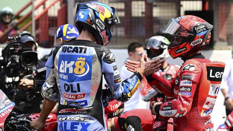 First-placed Ducati Lenovoi Team's Spanish MotoGP rider Marc Marquez (R) shakes hands with second-placed BK8 Gresini Racing MotoGP team's Spanish MotoGP rider Alex Marquez (L) as they celebrate after the sprint on the eve of the Italian Moto GP Grand Prix at Mugello circuit, in Mugello, near Florence, on June 21, 2025. (Photo by Tiziana FABI / AFP)