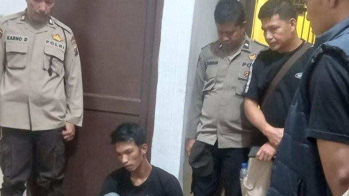 Pelaku Johan (duduk) usai diamankan petugas kepolisian. (Dok. Polres Pematangsiantar)