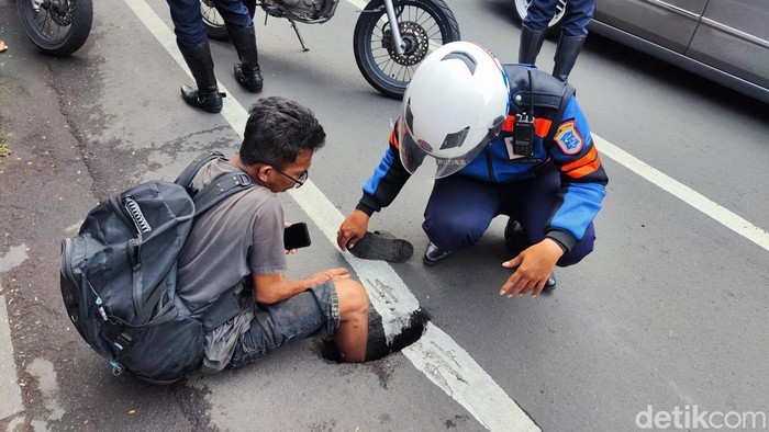 Seorang pejalan kaki mengalami luka lecet usai kakinya masuk ke lubang drainase di Jalan Gubernur Suryo Surabaya saat hendak menyeberang jalan.