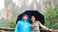 Lucu ya melihat Anang Hermansyah berfoto memakai jas hujan.