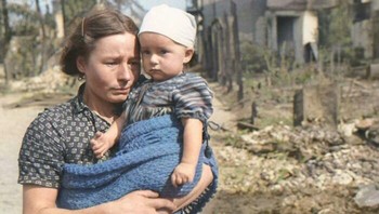 Seorang wanita Polandia, menggendong anaknya yang masih kecil, berdiri di jalan Warsawa yang telah dihancurkan oleh serangan bom Luftwaffe pada awal Perang Dunia II di Eropa - September 1939 Foto: Boredpanda