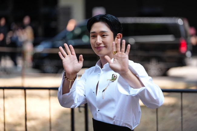 Penampilan Jung Hae In disempurnakan dengan detail bros berwarna emas yang tersemat pada bagian dada kirinya. Aktor 37 tahun itu juga mengenakan koleksi cincin dan gelang mewah yang senada. Foto: Getty Images/Edward Berthelot