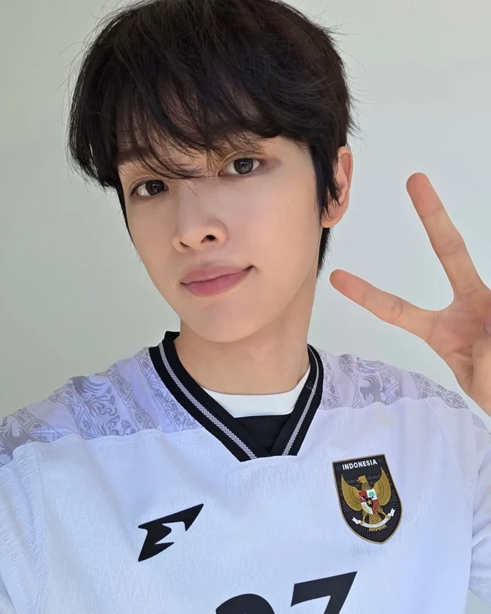 Sungchan, personel RIIZE, menggunakan jersey tandang Timnas Indonesia.