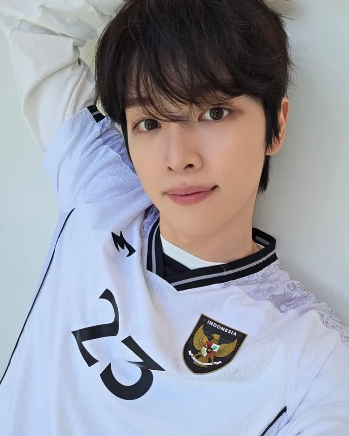 Sungchan, personel RIIZE, menggunakan jersey tandang Timnas Indonesia.