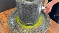Tak hanya menikmati pemandangan kebun teh, di Chazuna pengunjung juga bisa membuat matcha. Salah satunya belajar menggiling teh sendiri secara manual. Foto: Instagram/uji_chazuna