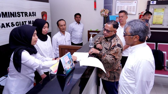 Anggota Kompolnas Mohammad Choirul Anam (tengah berpakaian batik).