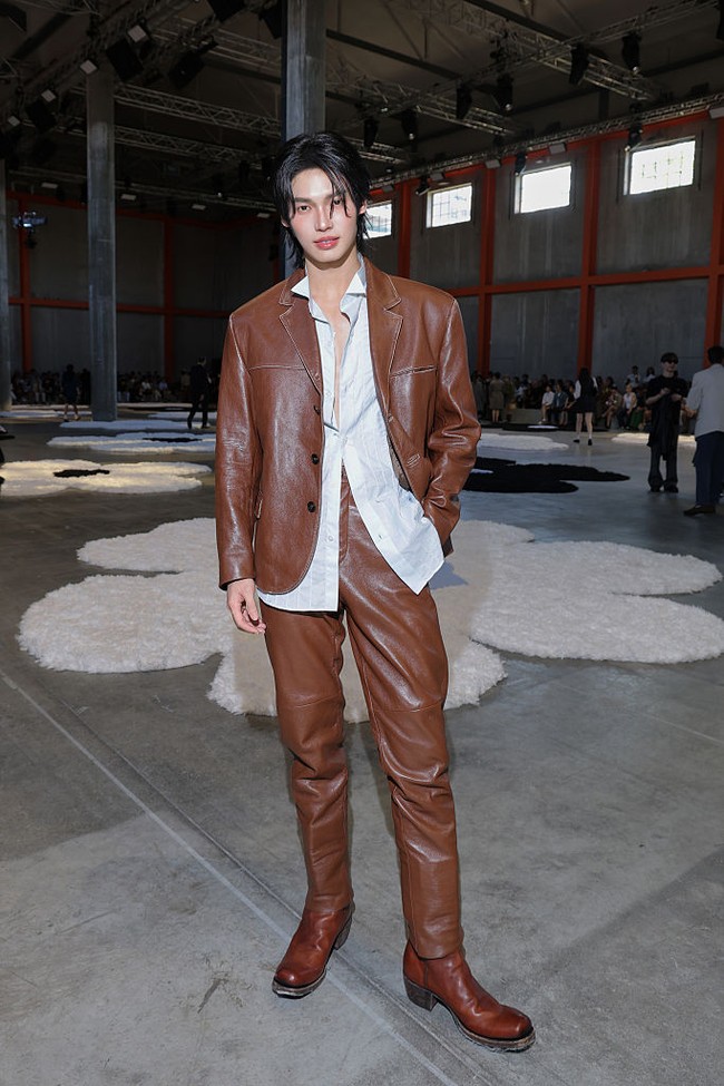 Dengan postur tubuh bak model, Win Metawin tampil karismatik memakai setelan kulit berwarna coklat. Di baliknya, Win memakai kemeja biru menerawang yang terbuka. Foto: Getty Images