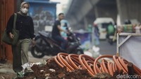 Pejalan kaki melintas di samping proyek galian kabel fiber. Gubernur DKI Jakarta Pramono Anung menekankan bahwa Jakarta akan cantik tanpa adanya kabel yang semrawut.