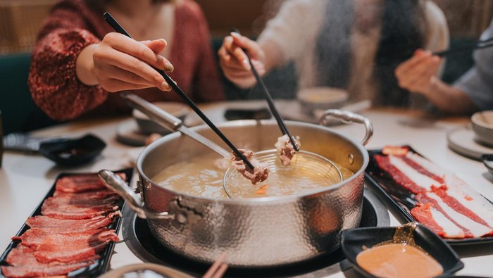 Happy Generation Z girls tavelling  in Zhuhai, Greater Bay Area, China, and having hotpot in a restaurant