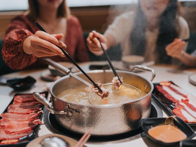 Happy Generation Z girls tavelling  in Zhuhai, Greater Bay Area, China, and having hotpot in a restaurant